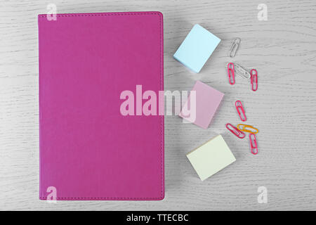 Farbige Clips und Aufkleber und Notebook auf weißen Tisch Stockfoto