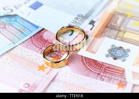 Goldene Hochzeit Ringe an Euro-banknoten Hintergrund. Der scheinehe Stockfoto