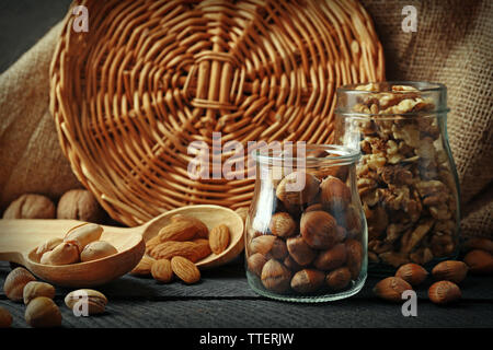 Mix der Schalenfrüchte in der Gläser und Löffel aus Holz, auf dem Tisch Stockfoto