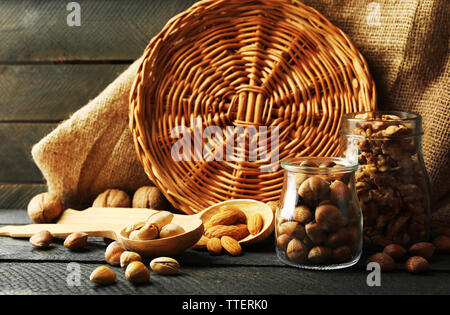 Mix der Schalenfrüchte in der Gläser und Löffel aus Holz, auf dem Tisch Stockfoto