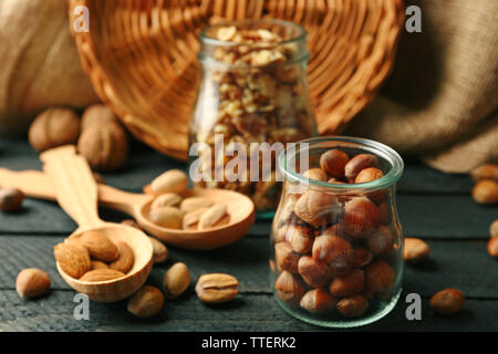 Mix der Schalenfrüchte in der Gläser und Löffel aus Holz, auf dem Tisch Stockfoto