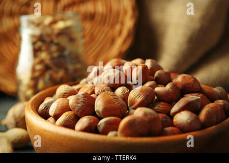 Haselnüsse, Walnüsse, Erdnüsse in der Schale und Glas auf dem Tisch, Nahaufnahme Stockfoto