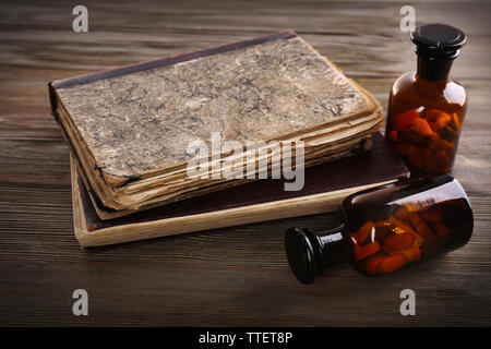 Bücher und Pillen auf Holztisch closeup Stockfoto