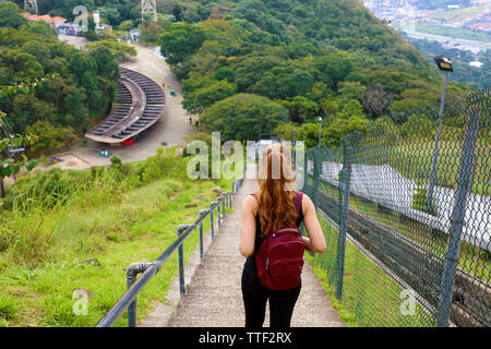 Junge touristische Mädchen tragen Rucksack Treppe und genießen den Blick von jaragua Peak, Brasilien Stockfoto