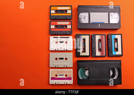 Satz von alten Audio- und Videokassetten auf rotem Hintergrund Stockfoto