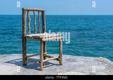 Holzstuhl in leeren Cafe neben Meer Wasser in tropischen Strand. Close Up. Insel Koh Phangan, Thailand Stockfoto