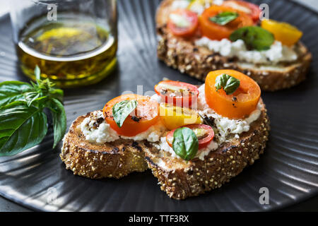 Bunte Cherry Tomaten und Ricotta Bruschetta durch Kräuter Olivenöl Stockfoto