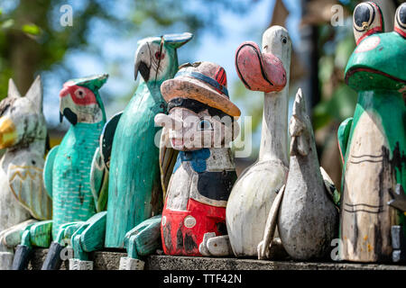 Alte hölzerne Souvenirs Spielzeug auf dem Stein Zaun in der Nähe der Puppe shop in Ubud, Bali, Indonesien. Nahaufnahme Stockfoto