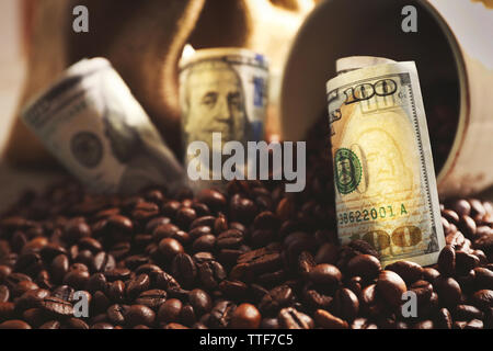 Kaffeebohnen, Tasse und US Dollar Banknoten auf hölzernen Hintergrund Stockfoto