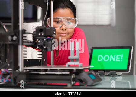 Junge Mädchen tragen Schutzbrille geduldig wartet auf Sie ein 3D-Drucker 3d-design Druck zu beenden. Stockfoto