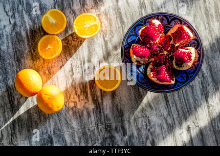 Draufsicht der Granatapfel und Orangen auf Tisch Stockfoto