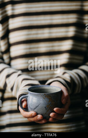 Frau mit einer Tasse Kaffee in den Händen. Stockfoto