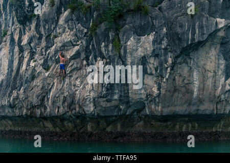 Man Deep Water Soloing über Wasser auf Kalkfelsen Stockfoto