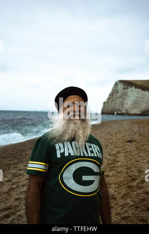 Ein alter Mann in einem turban steht am Strand in Dorset Stockfoto