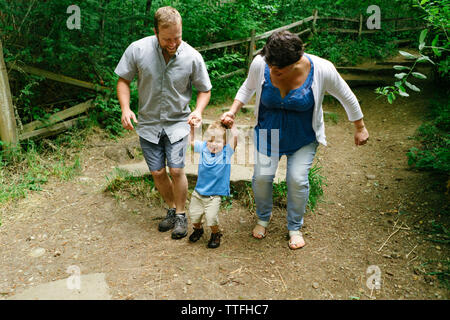 Gerade aus Sicht einer Familie springen Weg ein Schritt zusammen Stockfoto