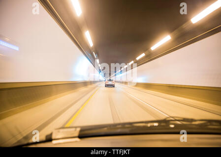 Auto bewegt sich in beleuchteten Tunnel gesehen obwohl Windschutzscheibe Stockfoto