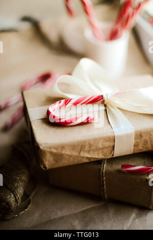 weihnachtsgeschenk mit Zuckerstangen auf Holztisch Stockfoto