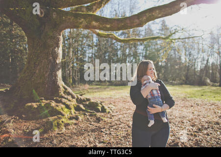 Die Mutter ihren Sohn im Freien Holding am Natur Park. Stockfoto