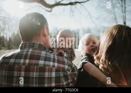 Baby und Kleinkind Blick über die Schulter der Eltern. Stockfoto