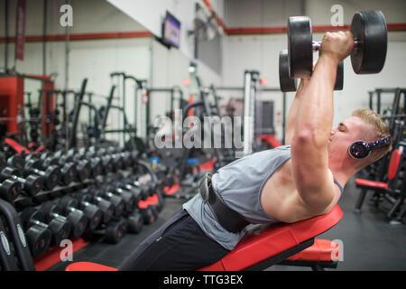 Passen tausendjährigen training Brustmuskeln mit Hanteln im Fitnessstudio Stockfoto