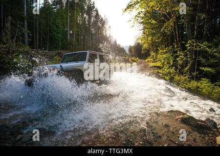 4x4 SUV (Jeep) Fahrt durch River in British Columbia. Stockfoto