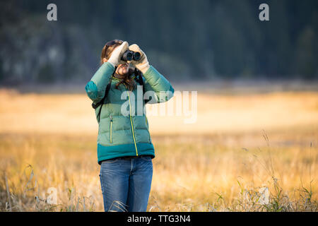 Junge Frau Vogelbeobachtung Mit dem Fernglas Stockfoto