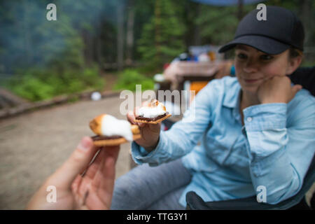 Paar Toasten mit ihren s'mores während einer kampierenden Reise Stockfoto