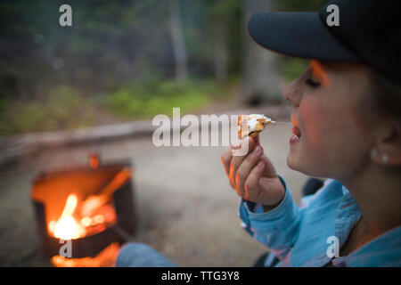 Frau essen smore beim Camping Stockfoto