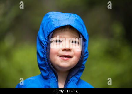 Portrait von kleinen Jungen tragen Kapuzenjacke in Regen Stockfoto