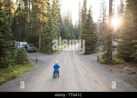 Kleinkind Radtouren durch die bewaldeten Campingplatz. Stockfoto