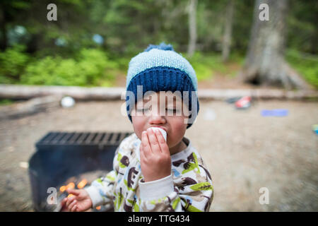 Toddler boy Essen ein Marshmallow während der Wartezeit zu machen s'mores Stockfoto