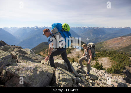 Zwei Bergsteiger eine felsige Kante in den Coast Mountains hinaufsteigen, B.C. Stockfoto