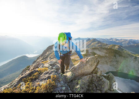 Backpacker kriecht über felsigen Grat, British Columbia, Kanada. Stockfoto