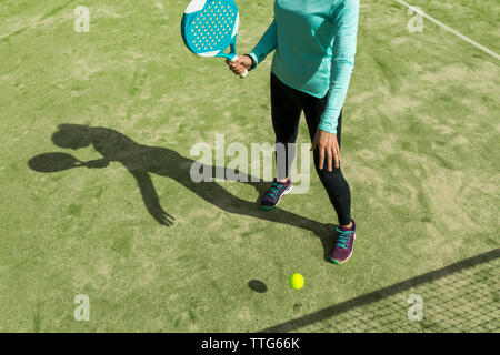 Niedrige Abschnitt der Frau spielen Paddle Tennis auf während der sonnigen Tag Stockfoto