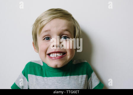 Close-up Portrait von jungen Aufeinanderpressen der Zähne gegen die Wand zu Hause Stockfoto