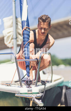 Segeln Mann an Deck und Vorbereitung Segelboot für die nächste Reise. Stockfoto