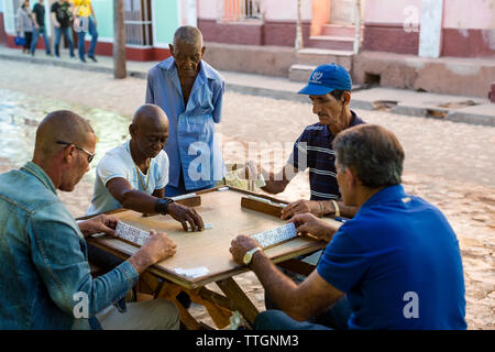 Ältere Herren spielen ein Spiel mit Dominosteinen in Trinidad, Kuba. 2017. Stockfoto