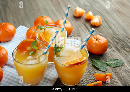 Tangerine Cocktails mit Eis, Minze und Strohhalme auf einen hölzernen Tisch serviert, in der Nähe Stockfoto