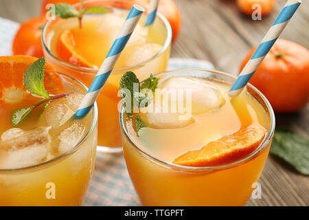 Tangerine Cocktails mit Eis, Minze und Strohhalme auf einen hölzernen Tisch serviert, in der Nähe Stockfoto