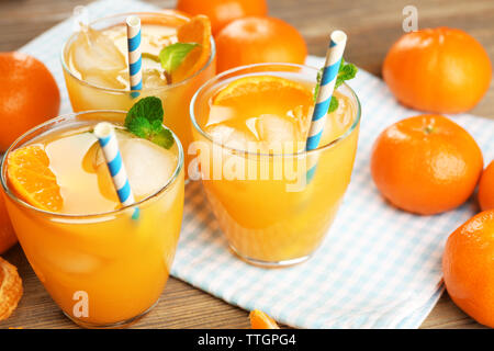Tangerine Cocktails mit Eis, Minze und Strohhalme auf einen hölzernen Tisch serviert, in der Nähe Stockfoto