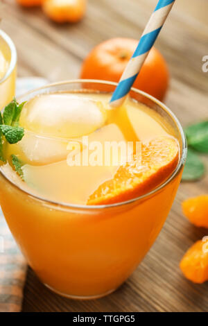 Köstliche tangerine Cocktails mit Eis, Minze und Strohhalme auf einen hölzernen Tisch serviert, in der Nähe Stockfoto