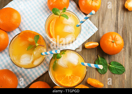 Köstliche tangerine Cocktails mit Eis, Minze und Strohhalme auf einen hölzernen Tisch serviert, Ansicht von oben Stockfoto