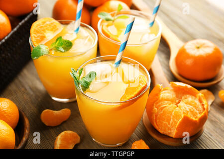 Tangerine Cocktails mit in Scheiben geschnittenen Mandarinen, Eis, Minze auf einem Holztisch, in der Nähe Stockfoto