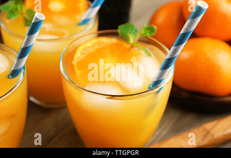 Tangerine Cocktails mit in Scheiben geschnittenen Mandarinen, Eis, Minze auf einem Holztisch, in der Nähe Stockfoto