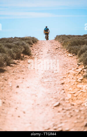 Oberfläche des Paares auf dem Fahrrad über Schmutz Trail gegen Sky Stockfoto
