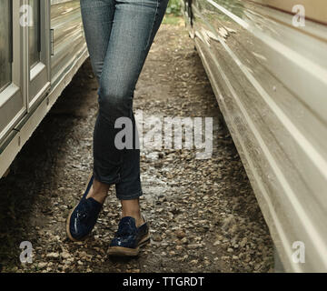 Woman's Beine in JEANS ZWISCHEN WOHNWAGEN Stockfoto