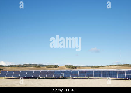 Sonnenkollektoren auf Landschaft gegen den blauen Himmel Stockfoto