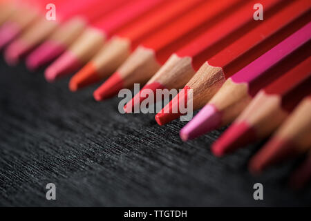 Aquarellstifte aufgereiht auf einem Schwarzen Tisch. Stockfoto