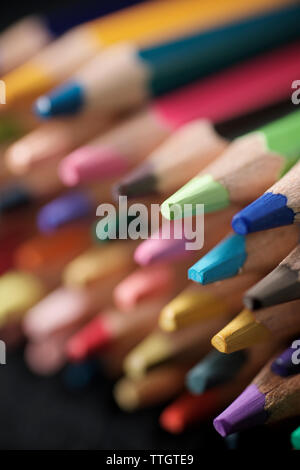 Aquarellstifte aufgereiht auf einem Schwarzen Tisch. Stockfoto