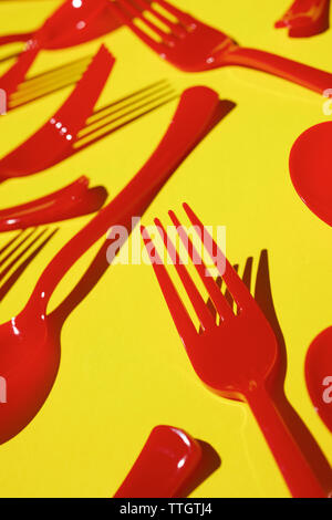 Rot aus Kunststoff Besteck auf einer gelben Tabelle. Stockfoto